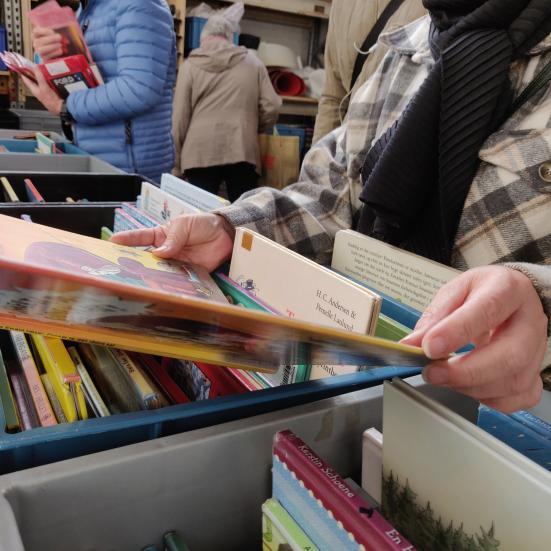 En person læser i en bog fra en bogsalgskasse