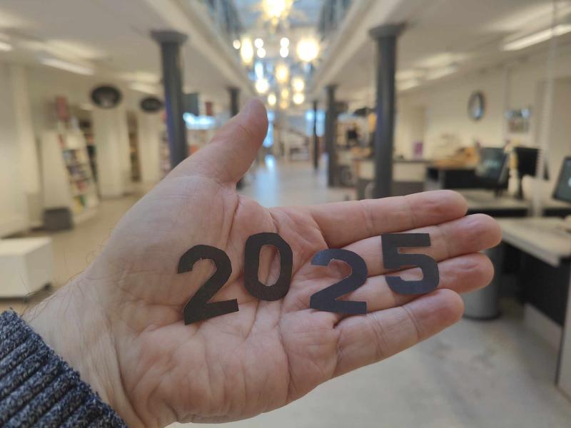 Håndflade med udklippede tal i papir: 2025.