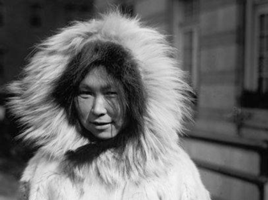 Arnarulunnguaq, stående i pelsfrakke med stor krave. Sort/hvidt fotografi fra 1924.